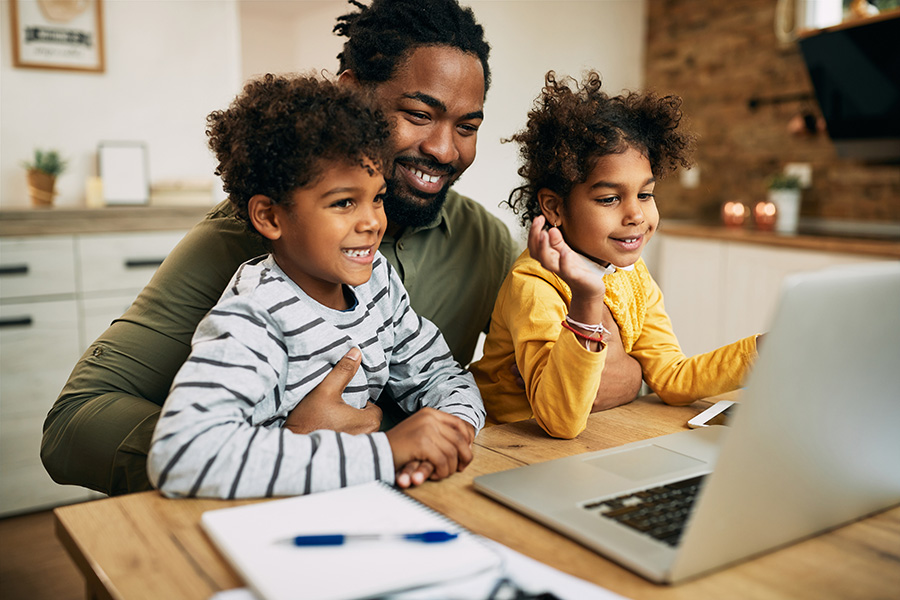 Man with children looking at laptop and health insurance prices