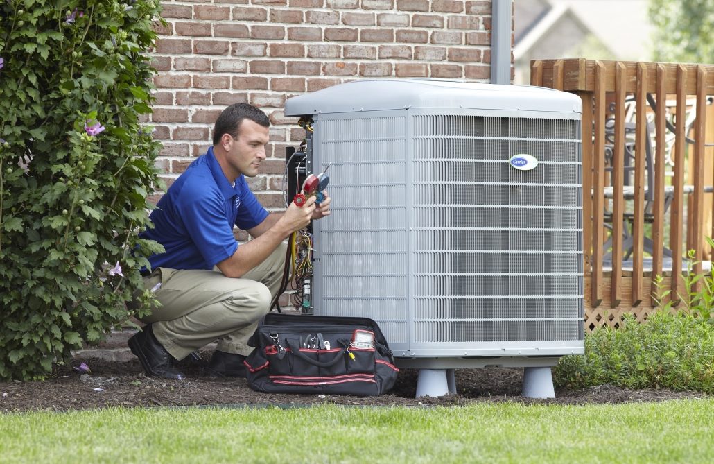 hvac technician repairing an ac unit outside of a house