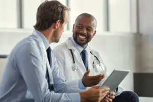 A direct primary care physician and his patient discussing healthcare outcomes.