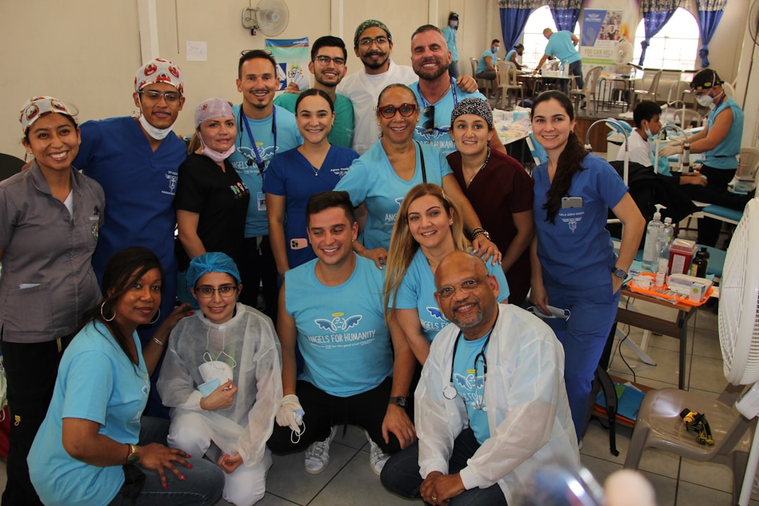 A diverse group of healthcare professionals in scrubs smiling, representing a valued and protected workforce. - business insurance for healthcare